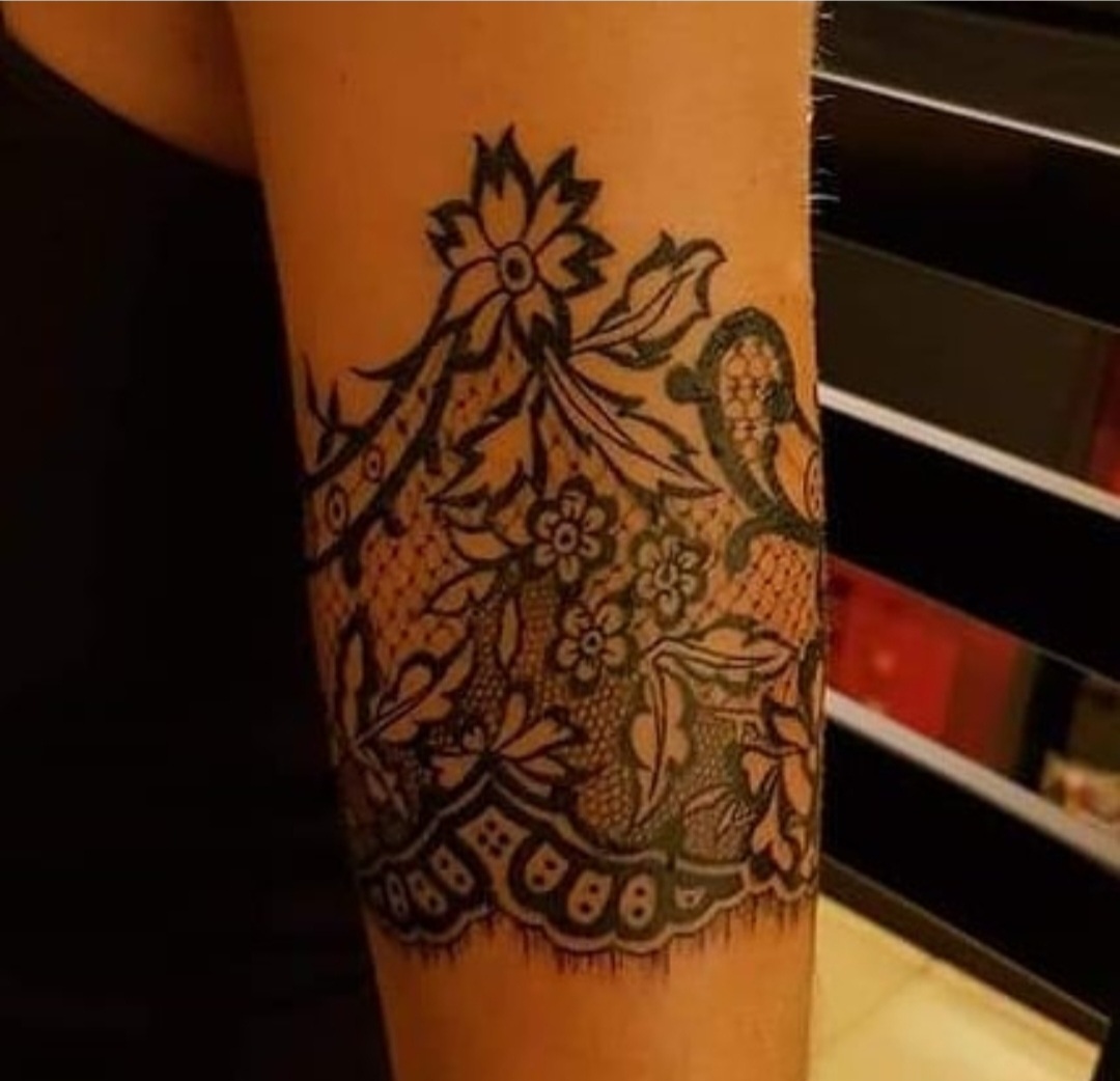 Tatouage floral et dentelle sur l'avant-bras